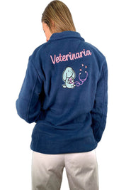 chaqueta forro polar veterinaria para mujer modelo guau de color azul marino con texto veterinaria en la espalda bordado y un perro de dibujos